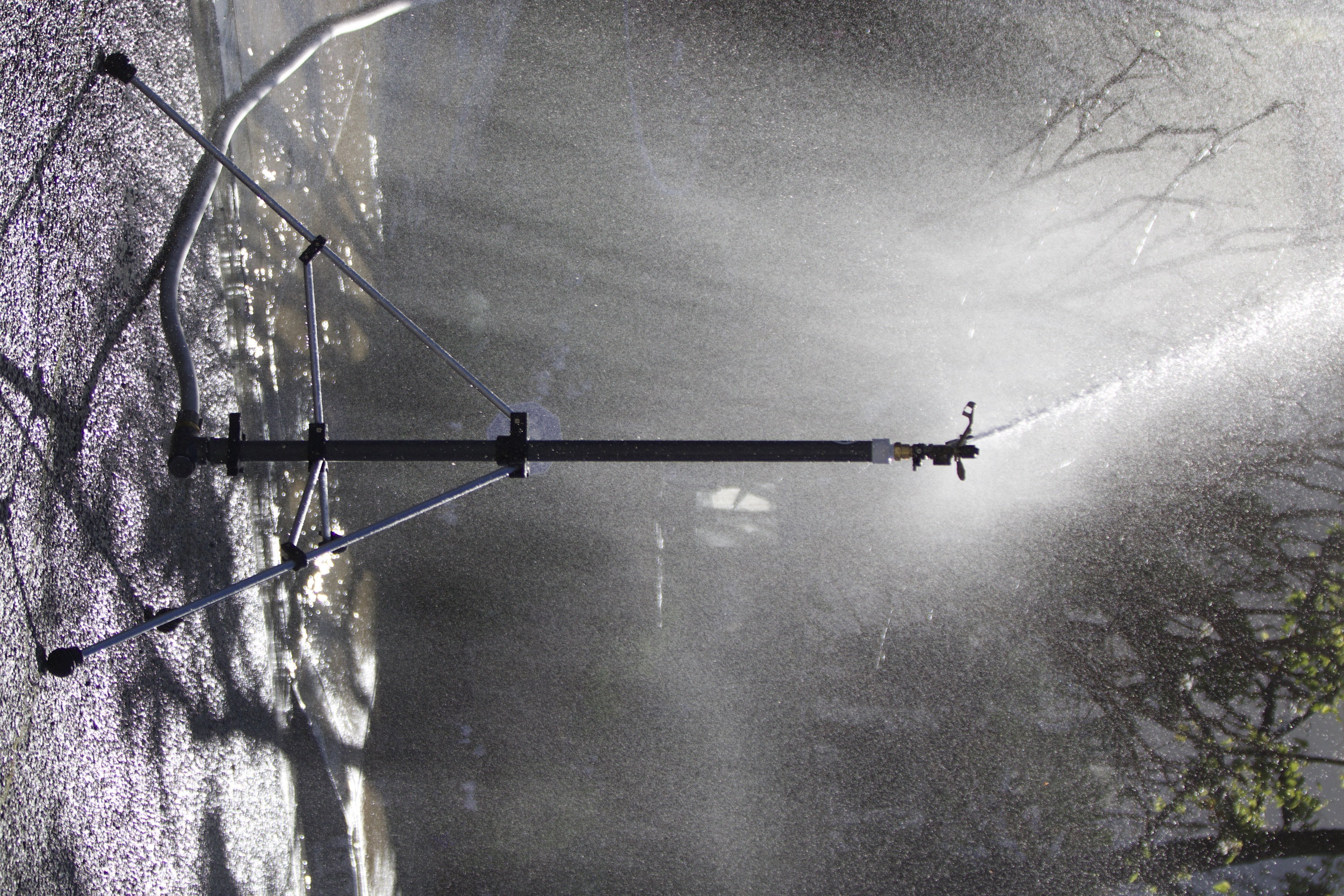 Attack tripod sprinkler delivering targeted zone defense around a property